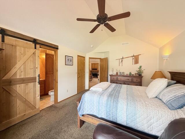 3086 S Suburban Ave, Springfield, MO 65807 - bedroom featuring vaulted ceiling, a barn door, carpet floors, ensuite bathroom, and ceiling fan