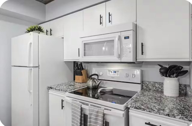 200 Golfview Dr Unit D5, Branson, MO 65616 - kitchen featuring white appliances, white cabinetry, and stone countertops