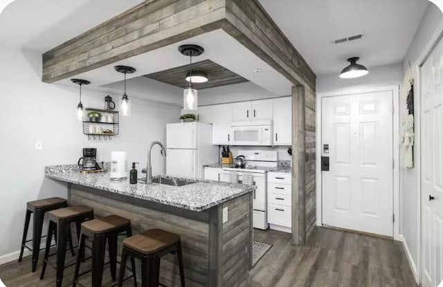 200 Golfview Dr Unit D5, Branson, MO 65616 - kitchen featuring a kitchen bar, white appliances, dark wood finished floors, a peninsula, and white cabinets