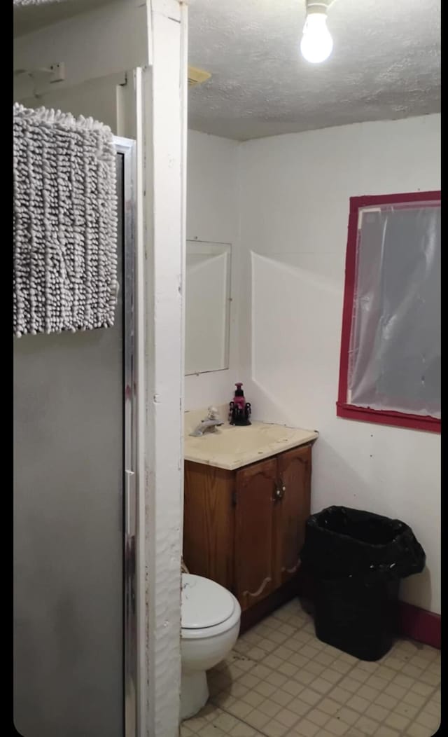 1885 N Lyon Ave, Springfield, MO 65803 - full bathroom featuring vanity, a walk in shower, a textured ceiling, and tile patterned floors