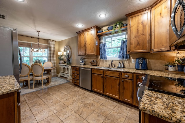 1021 W Whiteside St, Springfield, MO 65807 - kitchen with brown cabinets, decorative backsplash, plenty of natural light, and recessed lighting