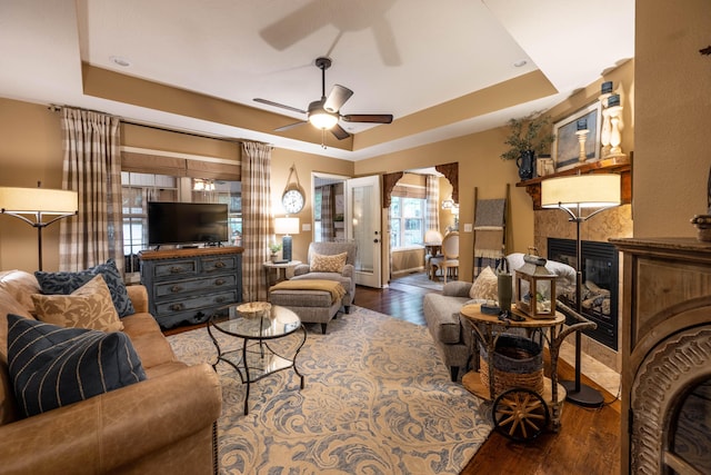 1021 W Whiteside St, Springfield, MO 65807 - living room with a raised ceiling, wood finished floors, a ceiling fan, and a tile fireplace