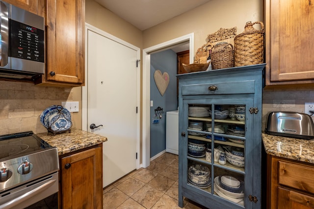 1021 W Whiteside St, Springfield, MO 65807 - kitchen featuring appliances with stainless steel finishes, tasteful backsplash, and brown cabinetry