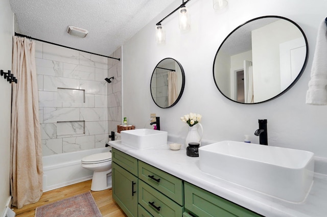 303 E Berkeley St, Springfield, MO 65807 - bathroom with wood finished floors, double vanity, shower / tub combo, and a textured ceiling