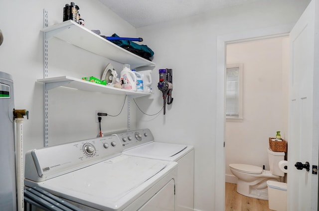 303 E Berkeley St, Springfield, MO 65807 - washroom featuring separate washer and dryer, light wood finished floors, and water heater