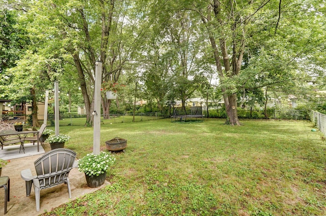 303 E Berkeley St, Springfield, MO 65807 - fenced backyard featuring a trampoline, a fire pit, and a patio area