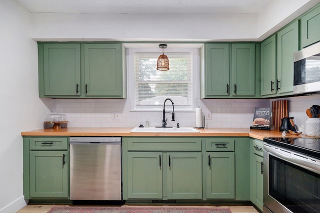 303 E Berkeley St, Springfield, MO 65807 - kitchen featuring green cabinetry, stainless steel appliances, backsplash, and wood counters