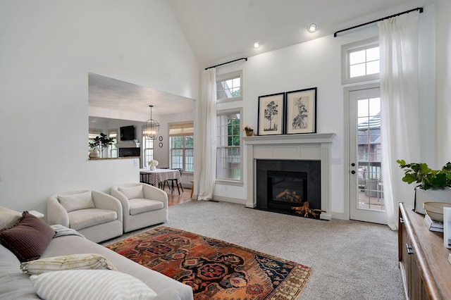 1421 N Rockingham Ave, Nixa, MO 65714 - carpeted living area with a high ceiling, a glass covered fireplace, and a chandelier