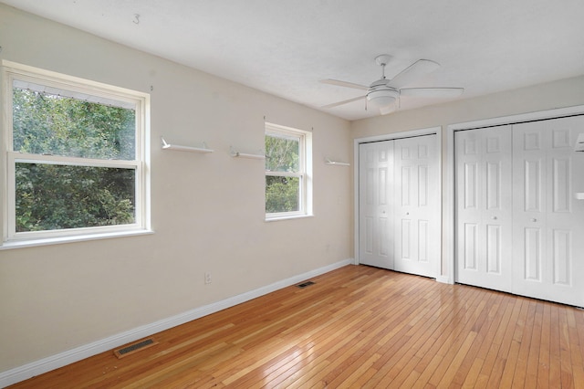 2001 S 16th Ave, Ozark, MO 65721 - unfurnished bedroom featuring two closets, light wood-type flooring, and ceiling fan