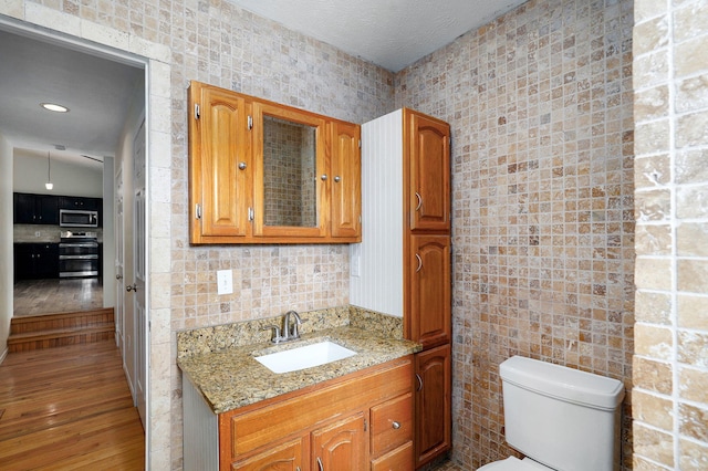 2001 S 16th Ave, Ozark, MO 65721 - bathroom featuring vanity, wood finished floors, and tile walls