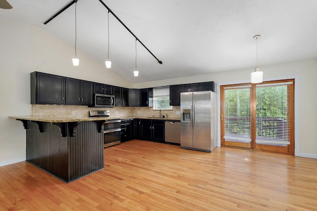 2001 S 16th Ave, Ozark, MO 65721 - kitchen featuring appliances with stainless steel finishes, light wood-type flooring, decorative backsplash, dark cabinetry, and light stone counters