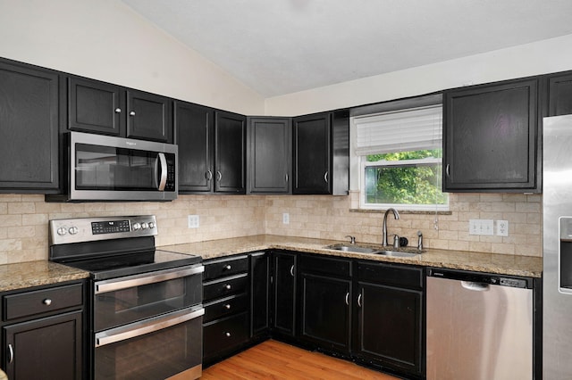 2001 S 16th Ave, Ozark, MO 65721 - kitchen featuring stainless steel appliances, dark cabinets, vaulted ceiling, and decorative backsplash