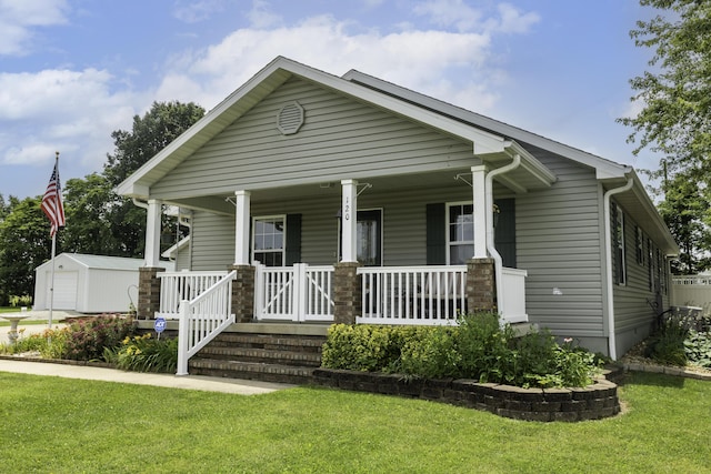 120 E Kennedy Blvd, Buffalo, MO 65622 - view of front facade with covered porch, a front lawn, an outdoor structure, and a detached garage