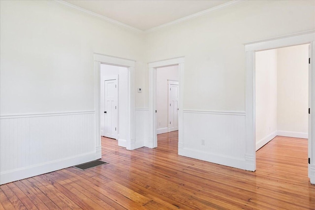 1156 W Lynn St, Springfield, MO 65802 - unfurnished room featuring crown molding, light wood-style flooring, and wainscoting