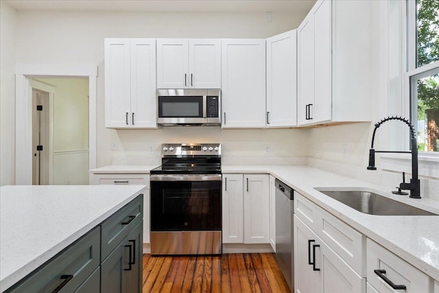 1156 W Lynn St, Springfield, MO 65802 - kitchen with stainless steel appliances, white cabinetry, light stone counters, and dark wood-style floors