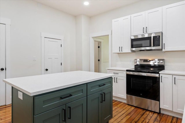 1156 W Lynn St, Springfield, MO 65802 - kitchen with stainless steel appliances, light countertops, white cabinetry, light wood-style floors, and a kitchen island