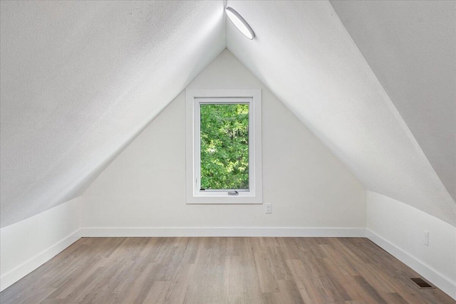 1156 W Lynn St, Springfield, MO 65802 - additional living space with wood finished floors, a textured ceiling, and vaulted ceiling