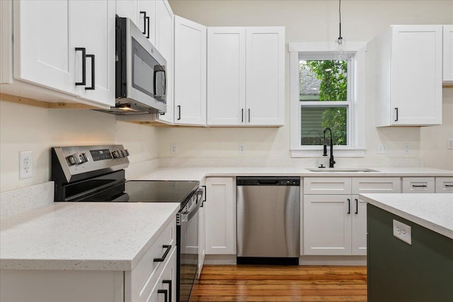 1156 W Lynn St, Springfield, MO 65802 - kitchen featuring appliances with stainless steel finishes, white cabinets, and light stone countertops