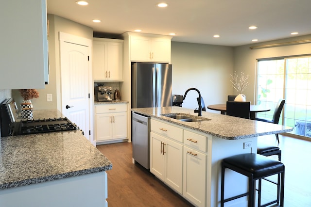1224 S Mulberry Ave, Springfield, MO 65802 - kitchen with appliances with stainless steel finishes, a kitchen bar, recessed lighting, dark wood finished floors, and white cabinetry