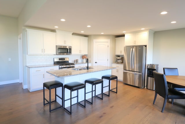 1224 S Mulberry Ave, Springfield, MO 65802 - kitchen featuring appliances with stainless steel finishes, backsplash, a breakfast bar area, dark wood-type flooring, and recessed lighting