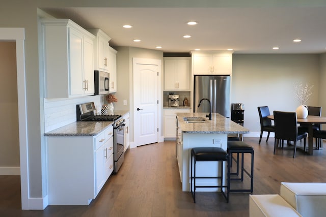 1224 S Mulberry Ave, Springfield, MO 65802 - kitchen featuring stainless steel appliances, backsplash, a breakfast bar, white cabinetry, and recessed lighting