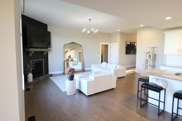 1224 S Mulberry Ave, Springfield, MO 65802 - living area with dark wood-style flooring, recessed lighting, a large fireplace, a chandelier, and arched walkways