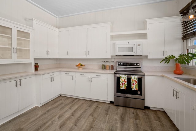 3821-B Ohuohu Rd, Koloa, HI 96756 - kitchen with electric stove, white microwave, light countertops, light wood-style flooring, and white cabinets