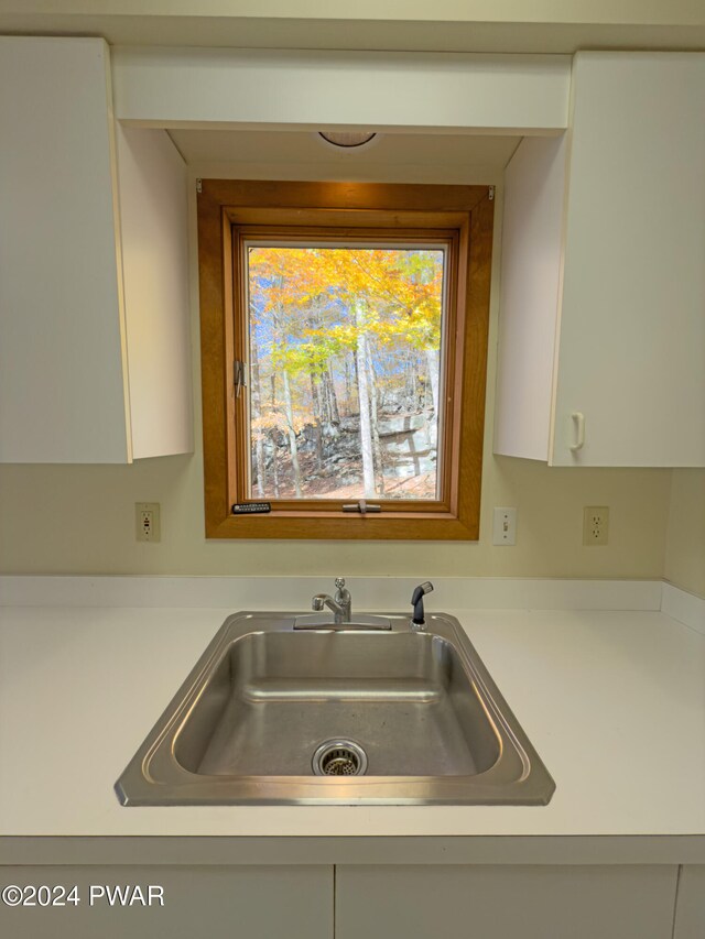 kitchen featuring white cabinetry and sink