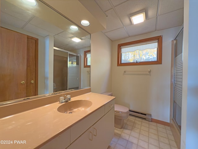 bathroom featuring walk in shower, a baseboard heating unit, toilet, a paneled ceiling, and vanity