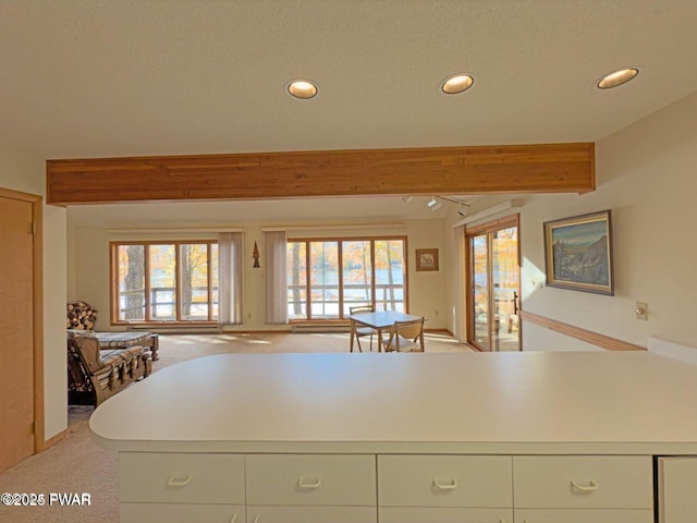 kitchen featuring recessed lighting, beam ceiling, open floor plan, and a healthy amount of sunlight