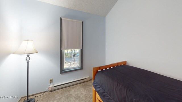 carpeted bedroom with a textured ceiling and a baseboard heating unit