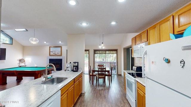 kitchen featuring sink, hanging light fixtures, white appliances, a fireplace, and pool table