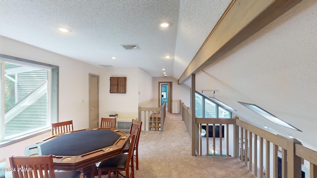 dining area featuring a textured ceiling and light colored carpet