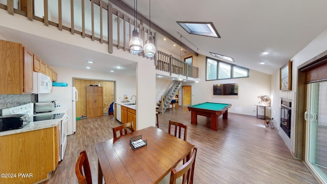 dining space featuring sink, high vaulted ceiling, wood-type flooring, and billiards