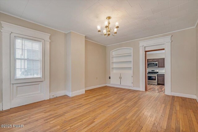 unfurnished dining area with built in features, light wood-type flooring, an inviting chandelier, and ornamental molding