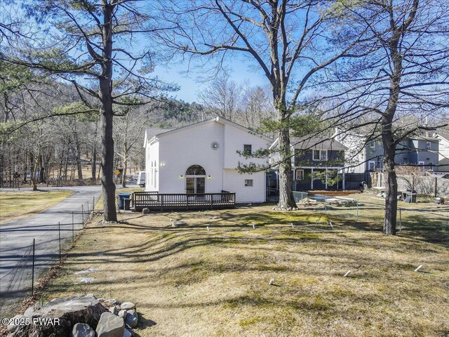 view of property exterior with a deck and a yard