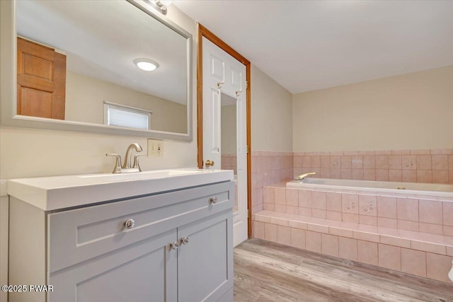 bathroom with vanity, a bath, and wood finished floors