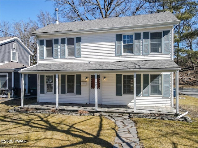 view of front facade featuring a porch, a front lawn, and roof with shingles