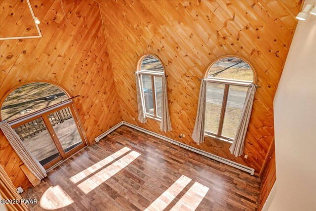 bonus room with wood finished floors and wood walls