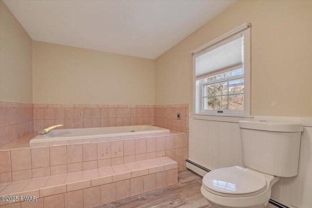 full bath with baseboard heating, toilet, a garden tub, and wood finished floors