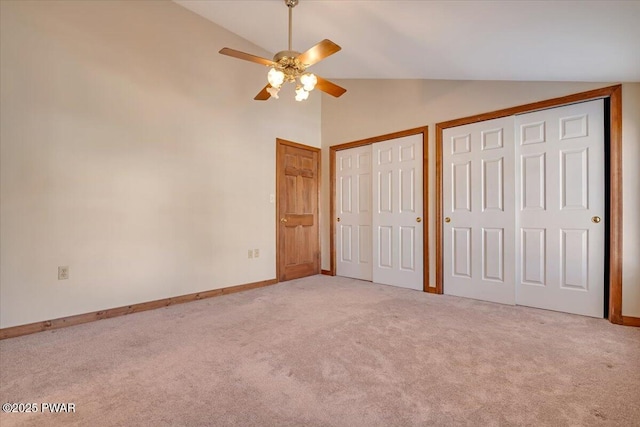 unfurnished bedroom with multiple closets, lofted ceiling, a ceiling fan, carpet, and baseboards