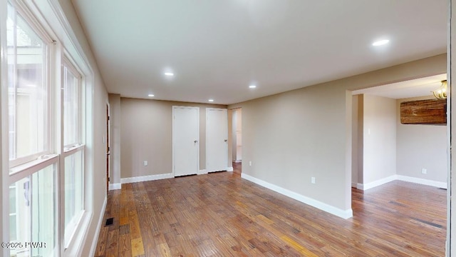 spare room with recessed lighting, baseboards, and wood finished floors