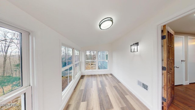 sunroom featuring lofted ceiling and visible vents