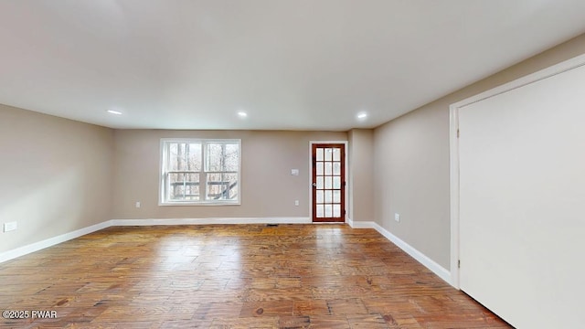 spare room featuring recessed lighting, baseboards, and wood finished floors