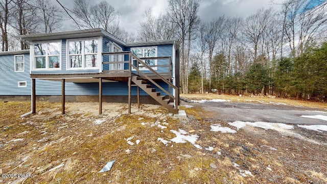 rear view of house featuring stairway and a wooden deck