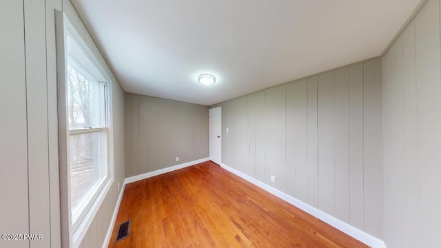 unfurnished room featuring light wood finished floors, baseboards, and visible vents