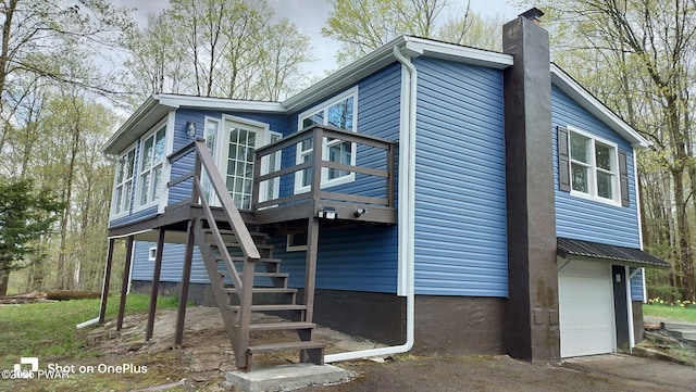 1 Mountain Crest Dr, Lake Ariel, PA 18436 - rear view of property featuring driveway, stairs, a chimney, a deck, and a garage