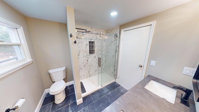 bathroom featuring toilet, a marble finish shower, baseboards, and a sink