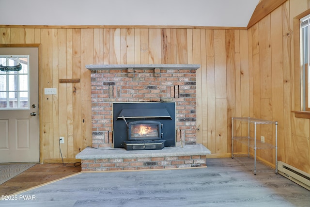 detailed view of a baseboard heating unit, wood finished floors, wood walls, and baseboards