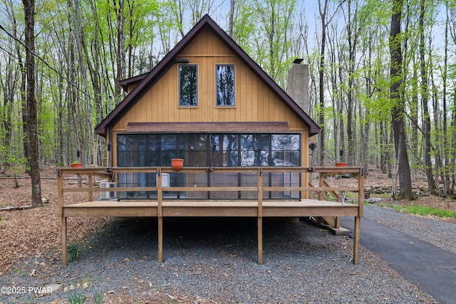 rear view of house with a chimney and a deck